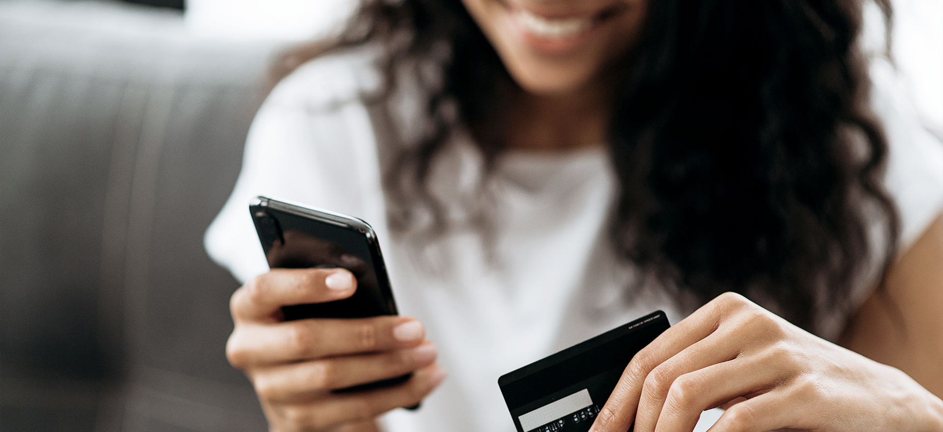Frau gibt Kreditkartennummer im Onlineshop ein