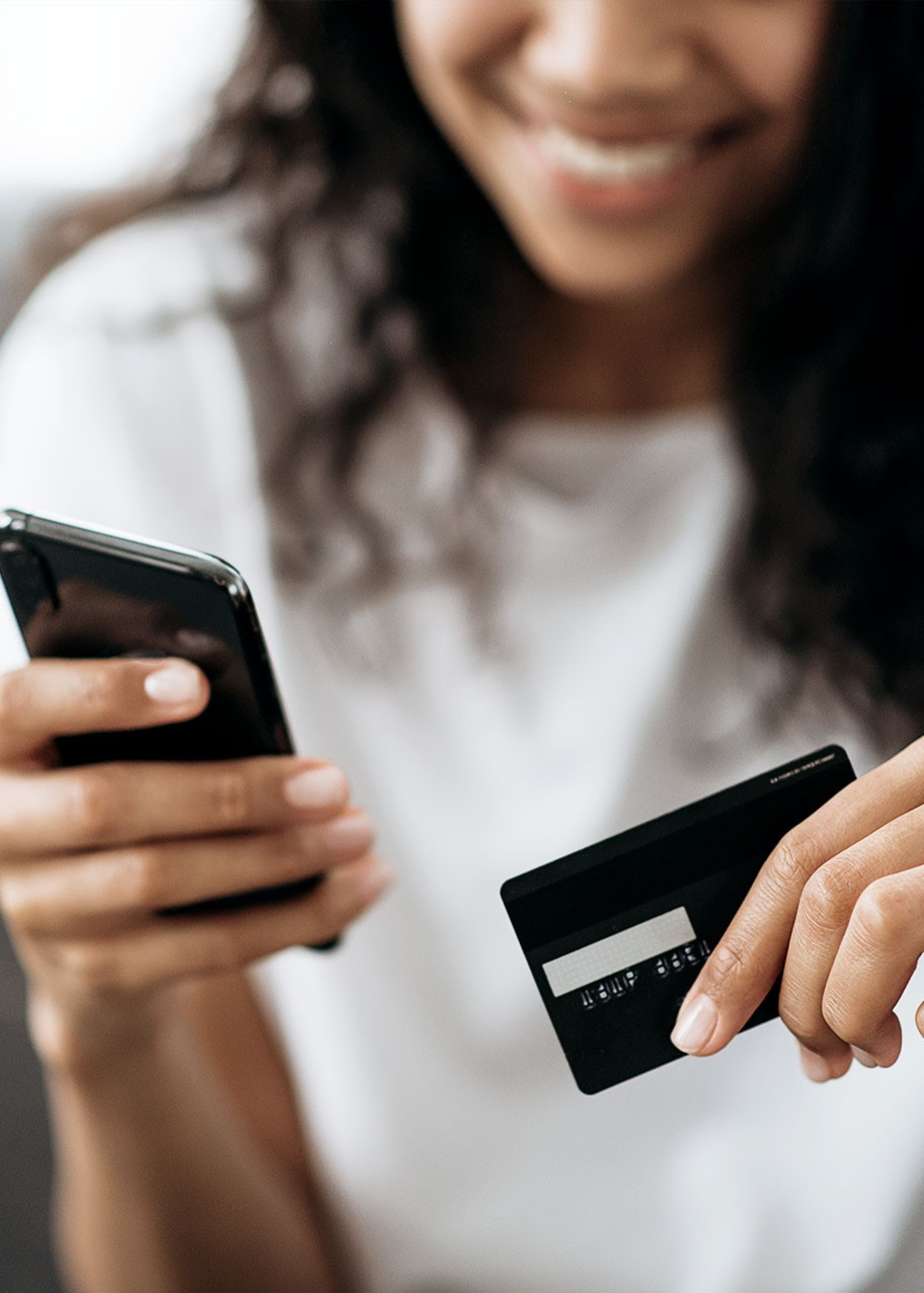 Frau hält Bankkarte und ihr Handy in der Hand