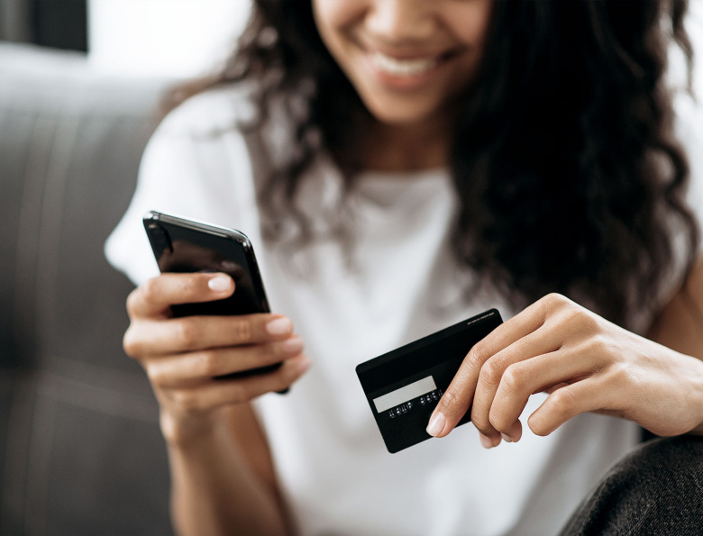 Frau gibt Kreditkartennummer im Onlineshop ein